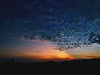 Low angle view of silhouette mountain against dramatic sky