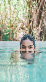 Portrait of young woman swimming in pool