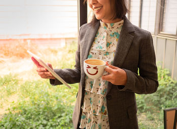 Midsection of woman holding coffee cup