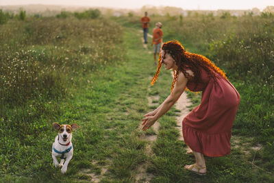 Beautiful woman plays with her jack russell dog in the park.