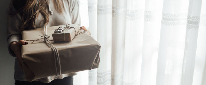 Midsection of woman holding window at home