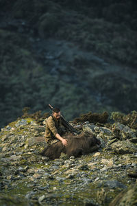 Hunter sitting near dead mountain goat