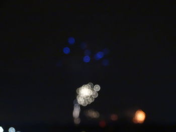 Low angle view of illuminated lights against sky at night