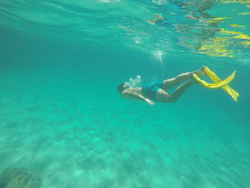 Shirtless man swimming undersea