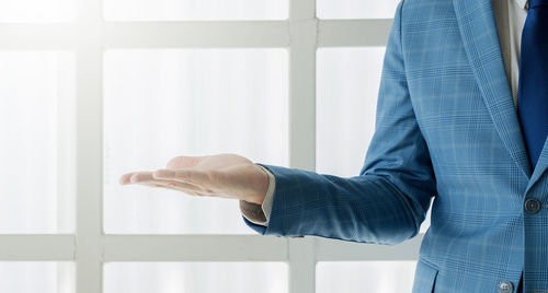 Midsection of man standing in front of window