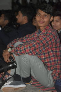 Portrait of young couple sitting on stage