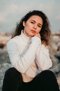 Portrait of young woman sitting outdoors