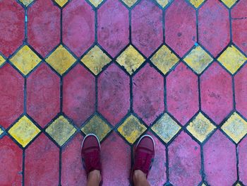 Low section of person standing on tiled floor