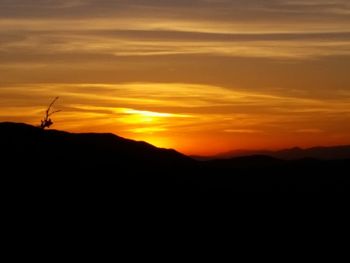 Silhouette landscape against sky during sunset