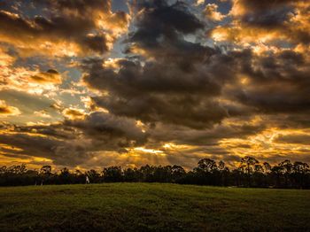 Scenic view of field against dramatic sky
