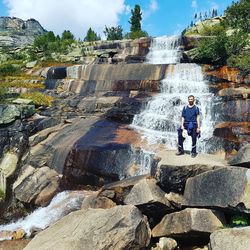 Full length of man on rock against waterfall