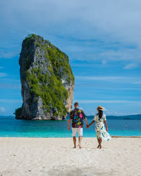 Couple holding hands standing on beach