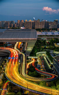 High angle view of light trails on road amidst buildings in city