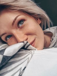 Close-up of beautiful woman relaxing on bed