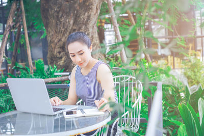 Young woman using laptop outdoors