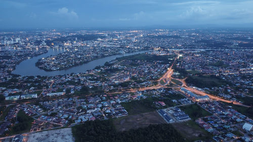 High angle view of illuminated cityscape against sky at night