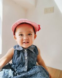 Portrait of cute baby girl sitting on sofa at home