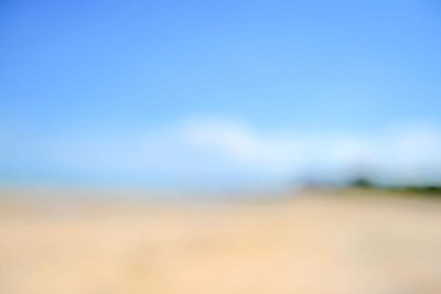 Defocused image of field against clear blue sky