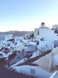 Houses on snow covered city against sky