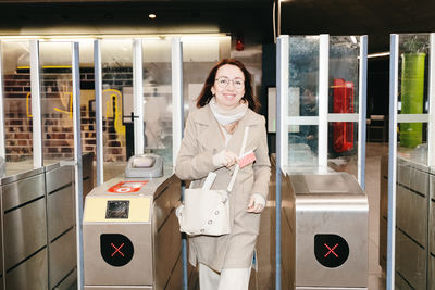 Portrait of a girl exiting the metro through a turnstile.