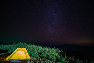 Tent in field against sky at night