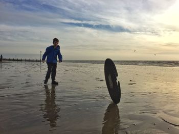 Full length of boy walking on shore at beach