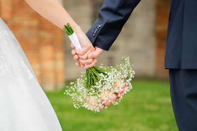 Close-up of hand holding bouquet of people