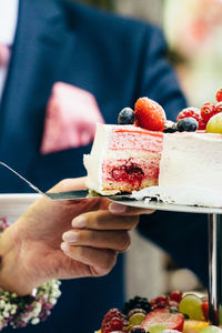 Midsection of woman holding wedding cake