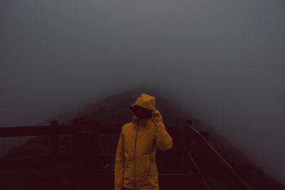 Woman wearing warm clothing during foggy weather