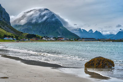 Scenic view of sea and mountains against sky