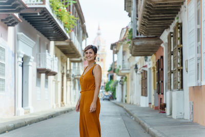 Portrait of young woman standing in city