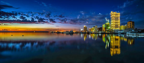 View of city at waterfront during sunset