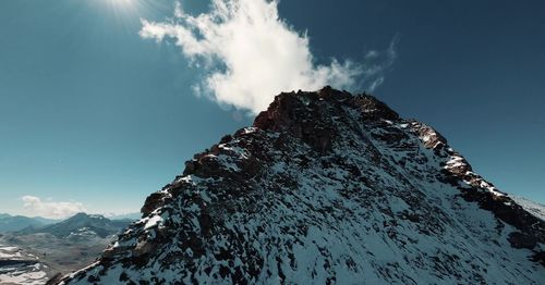 Low angle view of snowcapped mountains against sky