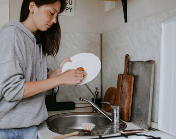 Midsection of woman working in kitchen