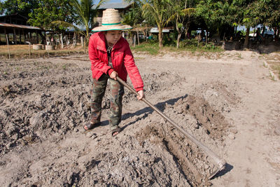 Female farmer wearing hat while working in farm