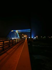 Illuminated bridge against clear sky at night