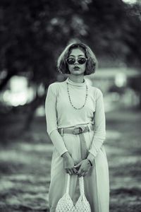 Portrait of woman wearing sunglasses standing outdoors