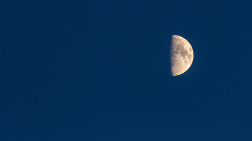 Low angle view of moon against blue sky