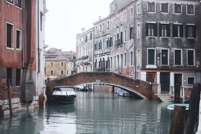 Bridge over canal amidst buildings in city