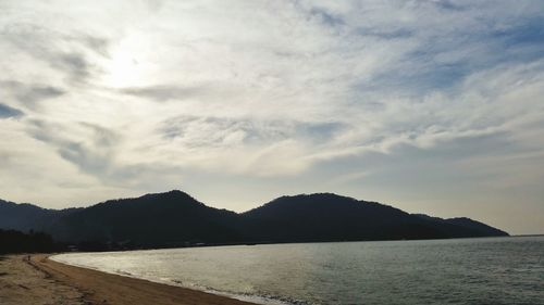 Scenic view of sea and mountains against sky