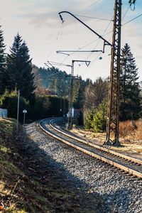 Railroad tracks by trees against sky