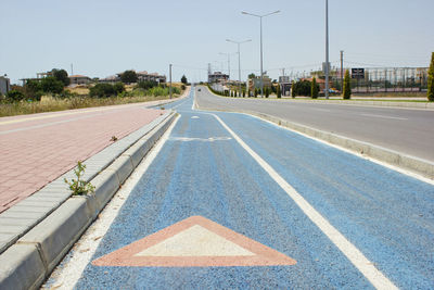 Empty road against sky in city