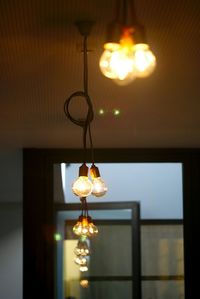 Illuminated chandelier hanging from ceiling