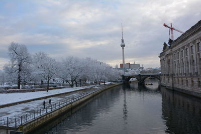 Bridge over river in city against sky