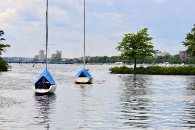Sailboats sailing in lake against sky