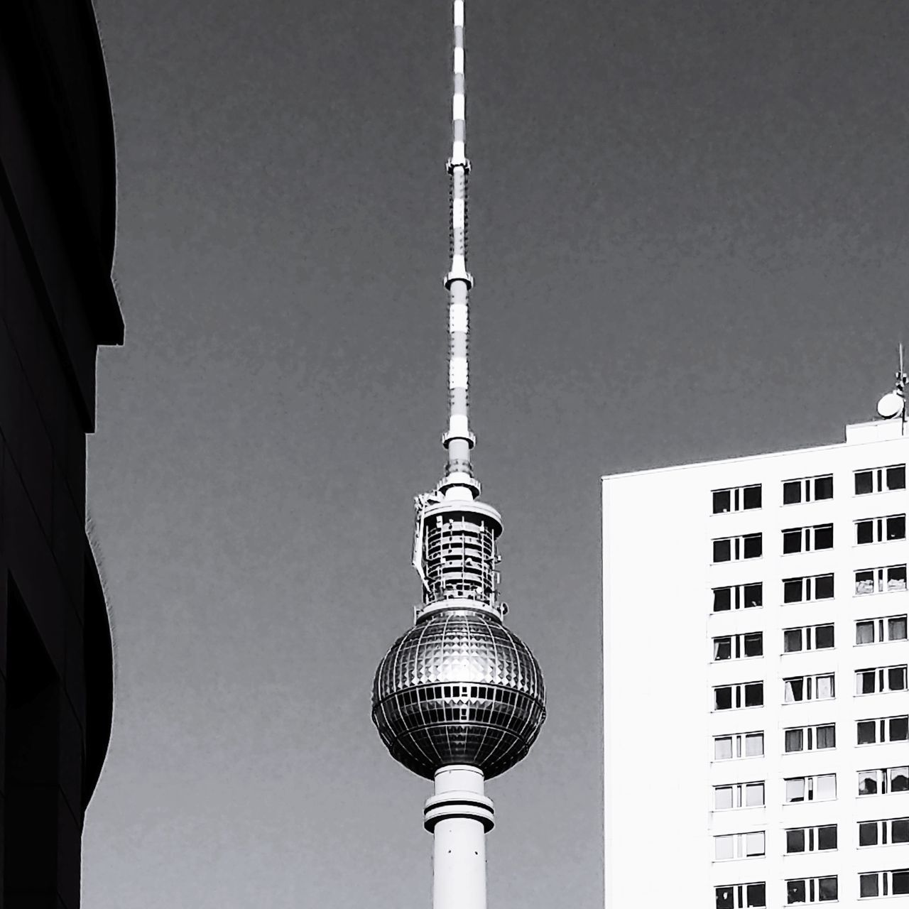 LOW ANGLE VIEW OF COMMUNICATIONS TOWER AGAINST BUILDINGS