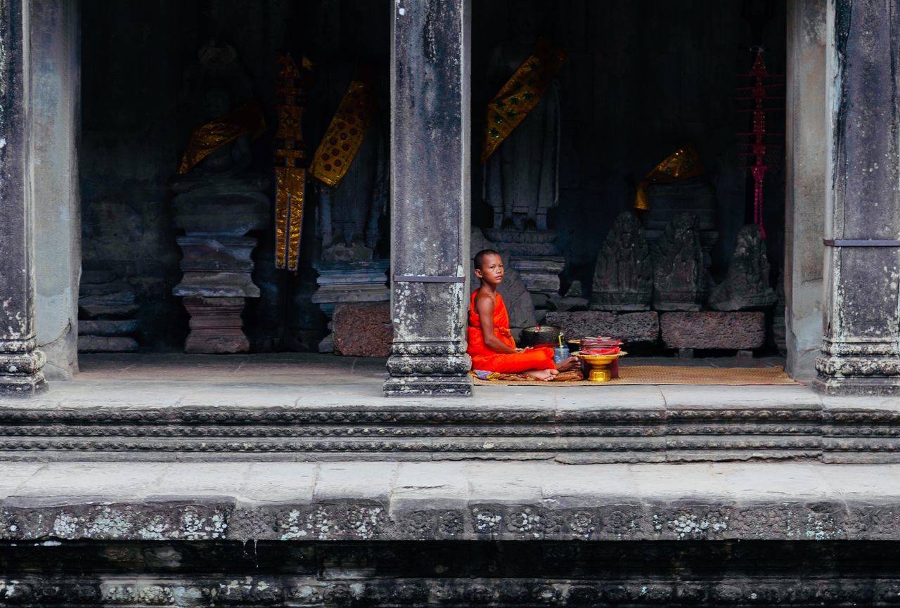 architecture, one person, religion, built structure, sitting, spirituality, building, real people, belief, place of worship, full length, day, building exterior, clothing, childhood, leisure activity, women, architectural column