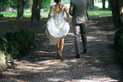 Low section of man and woman walking on road