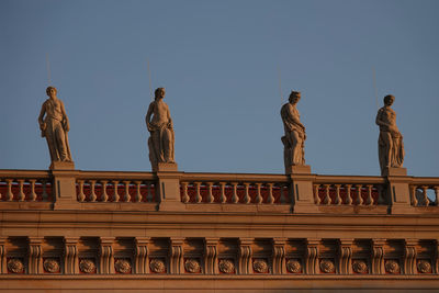 Low angle view of statues against clear sky