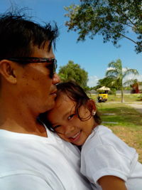 Close-up of father with daughter against sky